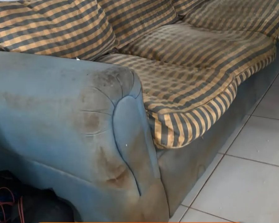 Sofá a cuadros muy sucio antes del servicio